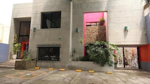 Un bâtiment moderne doté d’une fa çade en béton, d’un mur d’accent en pierre et d’un portail en métal.