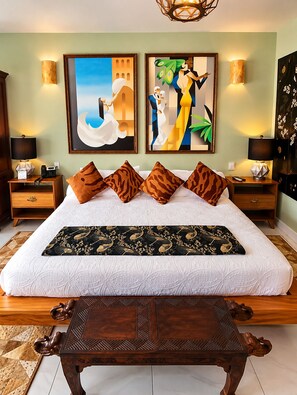 A hotel room with a large bed, two nightstands, a wooden table, and two wall-mounted lamps. - Hotel Boutique Ekléctic (Guadalajara)