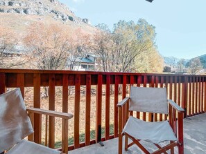 Ein Balkon mit zwei Stühlen und Blick auf eine Berglandschaft.