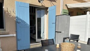 Eine Terrasse im Freien mit Tisch, gedeckt für zwei Personen, mit gewebten Körben und Keramiktassen.