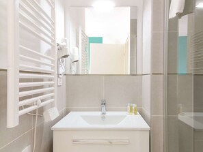 Ein Badezimmer mit Waschbecken, Spiegel und Handtuchhalter.