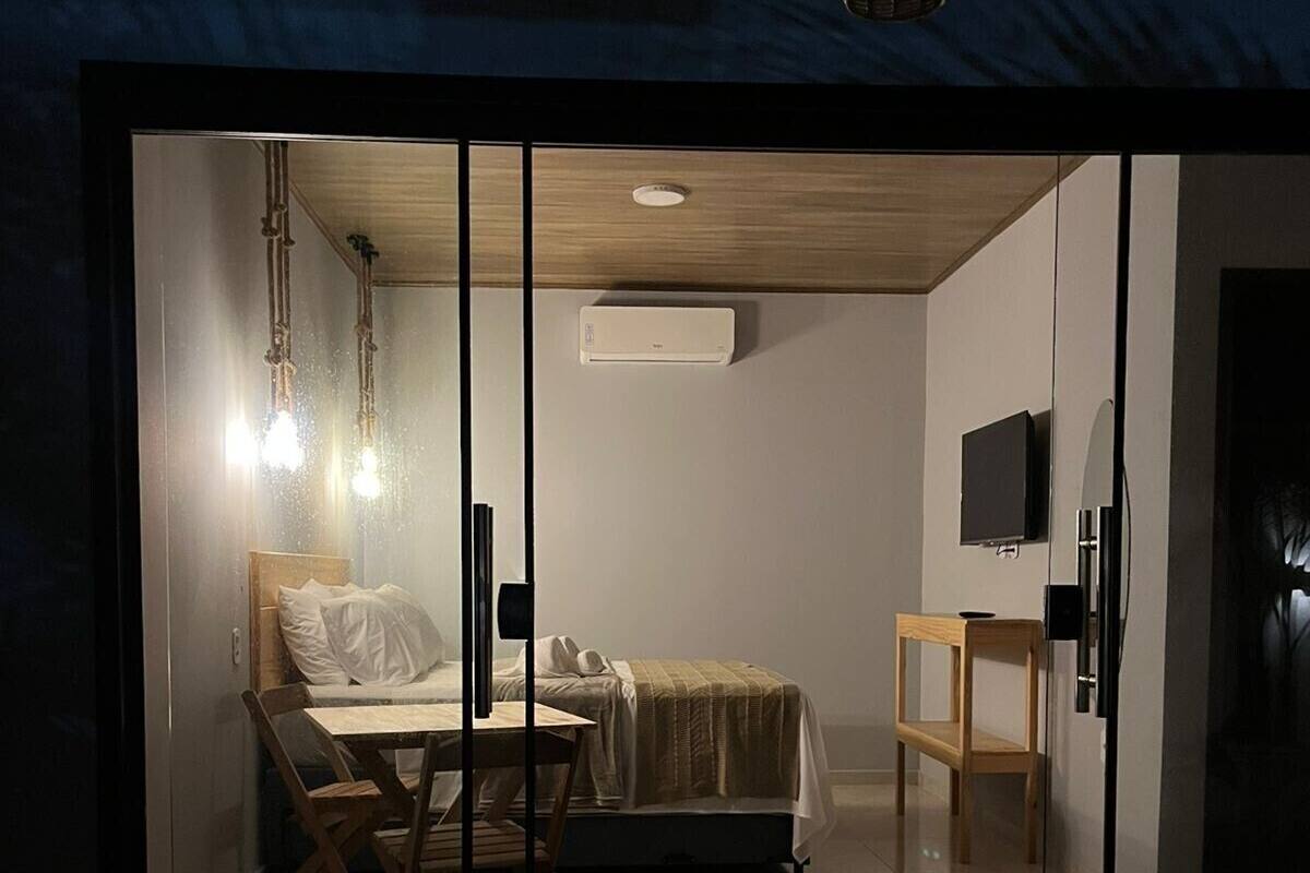 Une chambre comprenant un lit, un bureau, une chaise, un téléviseur et un appareil de climatisation.