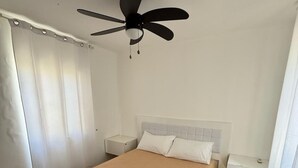 A bedroom with a bed, a ceiling fan, and a nightstand. - Pleasant 2-bedroom apartment with AC in Punta Cana (Punta Cana)