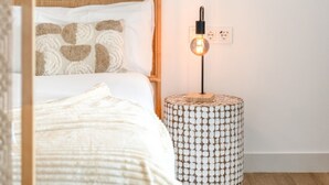 A neatly arranged bedroom with a bed, bedside lamp, and a framed artwork on the wall. - Stylish 2-pax Stay in Alcazaba Lagoon (Casares)