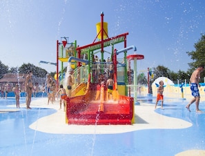 Un área de juegos acuáticos con varias toboganes y chorros de agua.