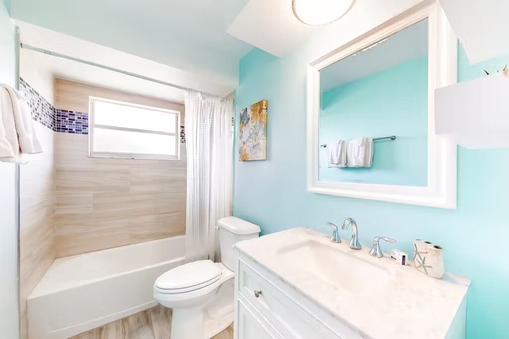 A bathroom with a bathtub, toilet, and sink.