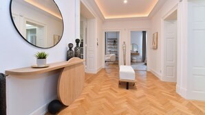 Une salle de bain moderne avec un meuble-lavabo en bois, un miroir rond et un banc.