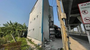 A building with a corrugated metal exterior, a gated entrance, and a sign prohibiting entry. - Charinsup Pinklao hotel (Bang Kruai)