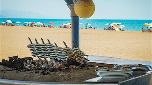 A beachside restaurant with a view of the ocean, tables with umbrellas, and a pile of fish on the ground. - Benahavis Abode With Panoramic Views (Benahavis)