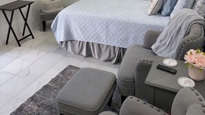 Une chambre moderne avec un lit, une télévision, une petite table et une chaise.