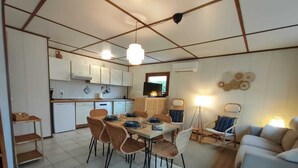 Un espace de vie compact comprenant un coin repas, une cuisine et un coin salon.
