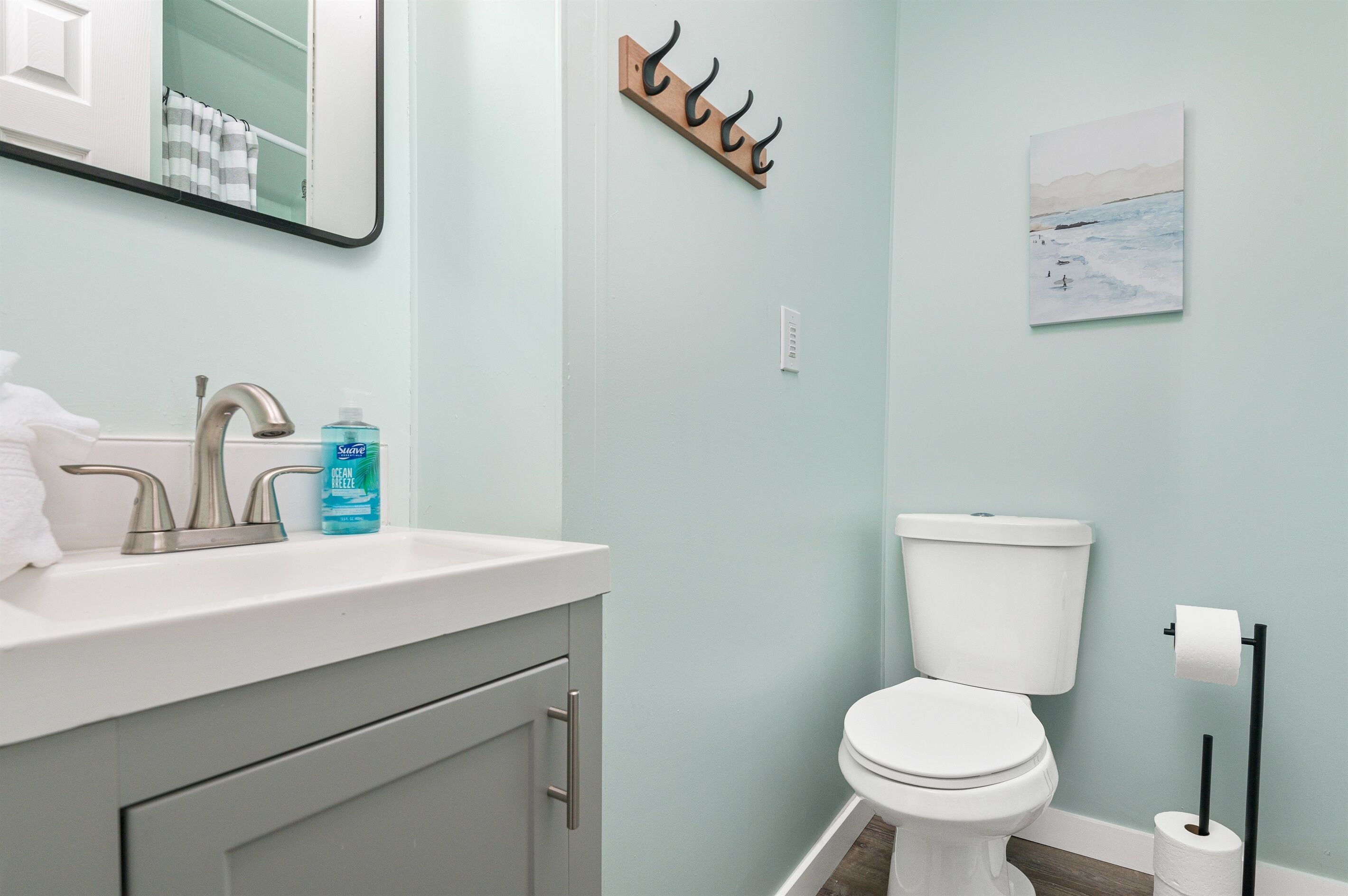 Une salle de bain équipée d’un lavabo, de toilettes et d’un porte-serviettes.