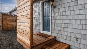 A wooden exterior with a dark blue door and the number 411. - Coral Cottage Unit #1: Walk to Beach, Pet Friendly (Rockaway Beach)