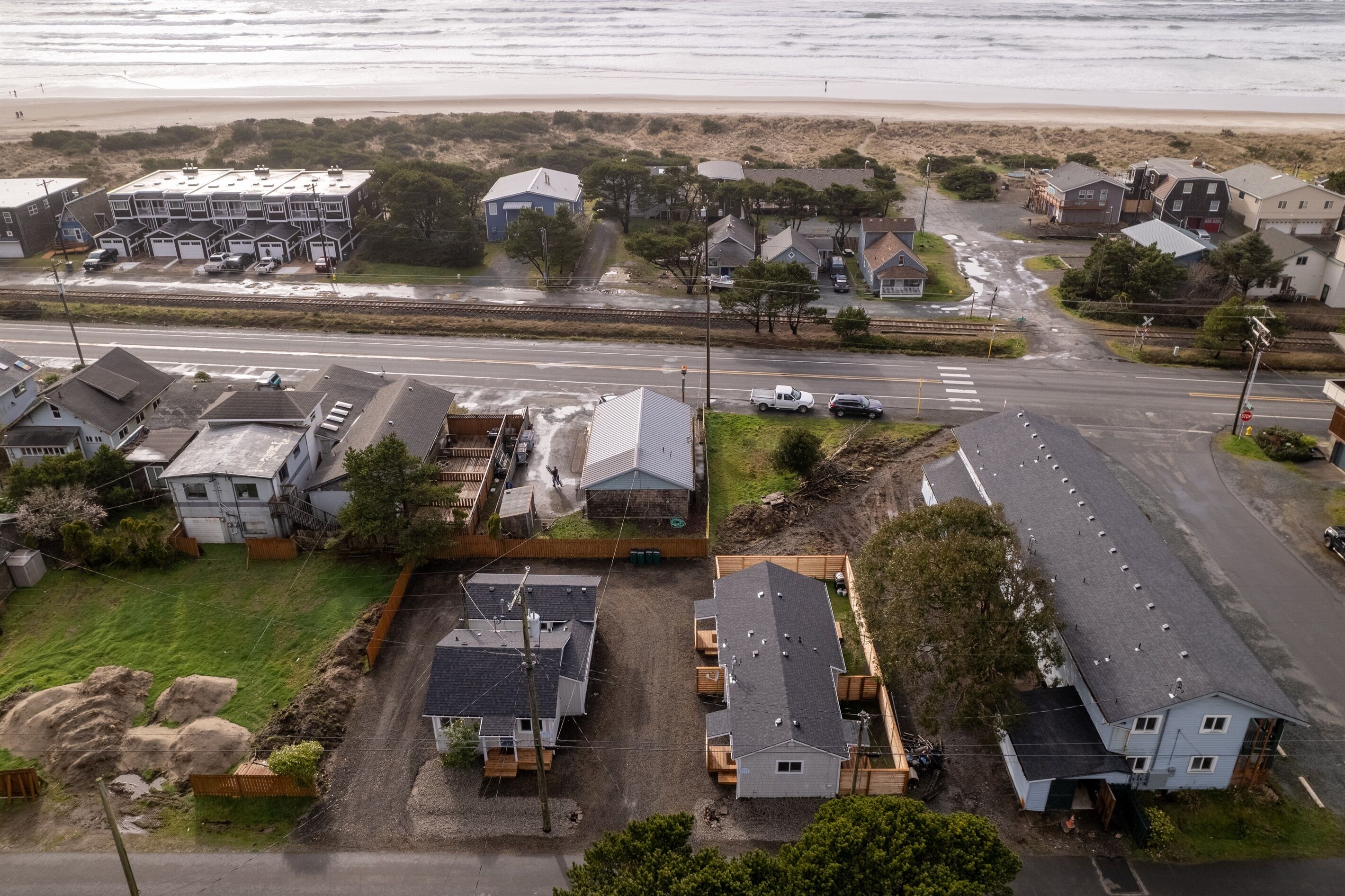 A coastal residential area with houses, a beach, and a road.