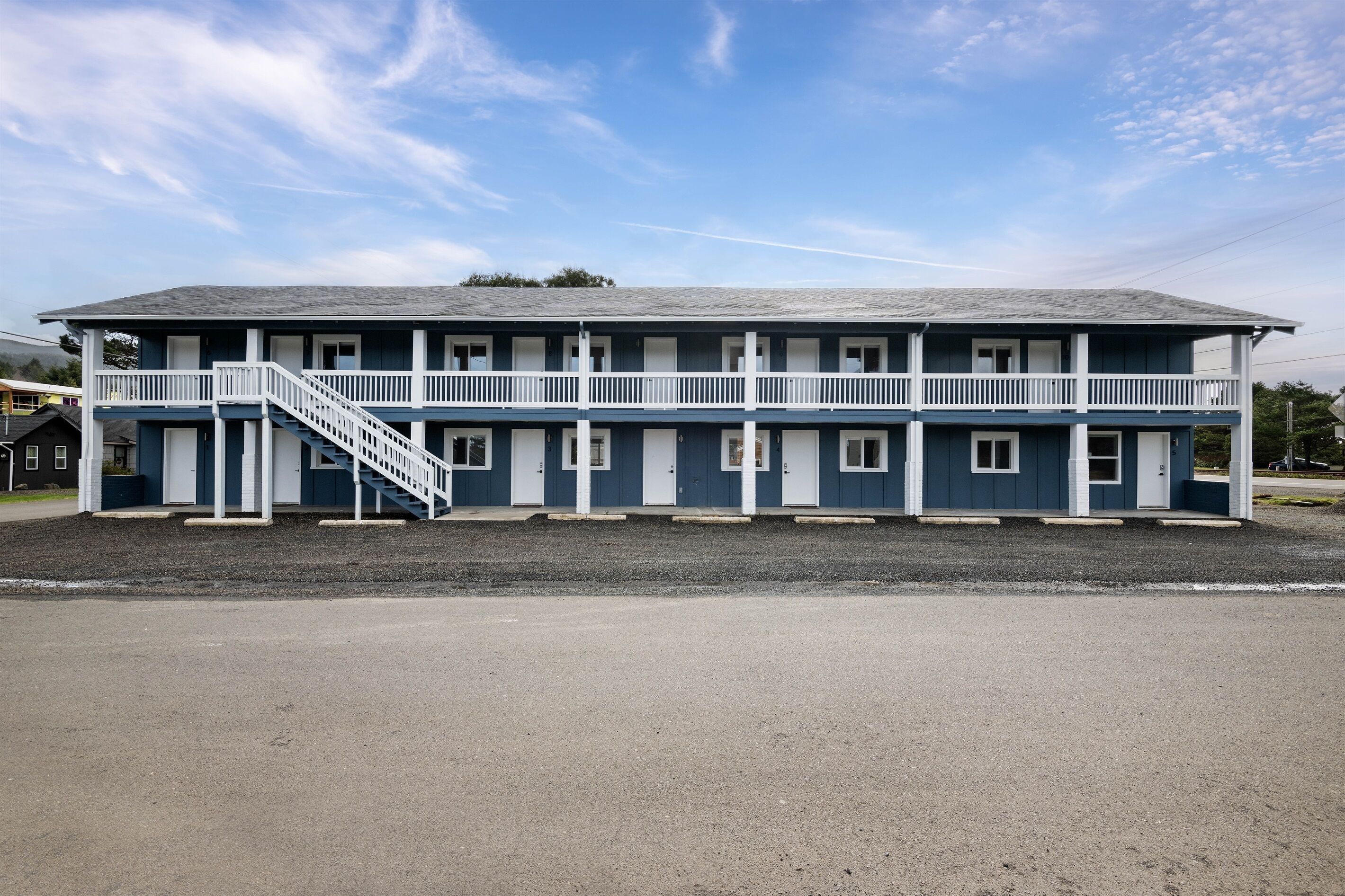 A two-story motel with a central staircase and a flat roof.