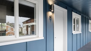 A building exterior with a blue exterior, white trim, and a door with a light fixture above it. - Inn at Rockaway Beach #9: Walk to Beach, Pets OK (Rockaway Beach)