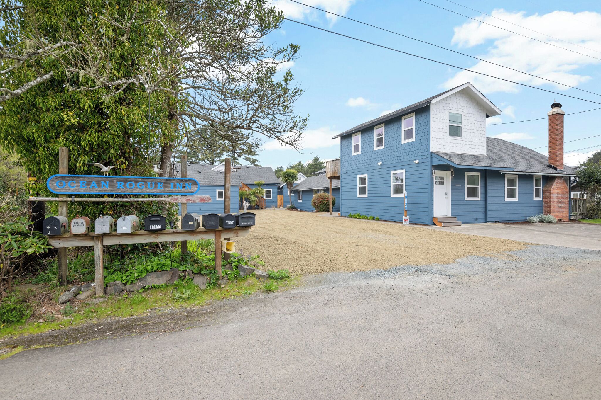 A blue building with a sign reading "OCEAN ROGUE INN" and a row of mailboxes in front.