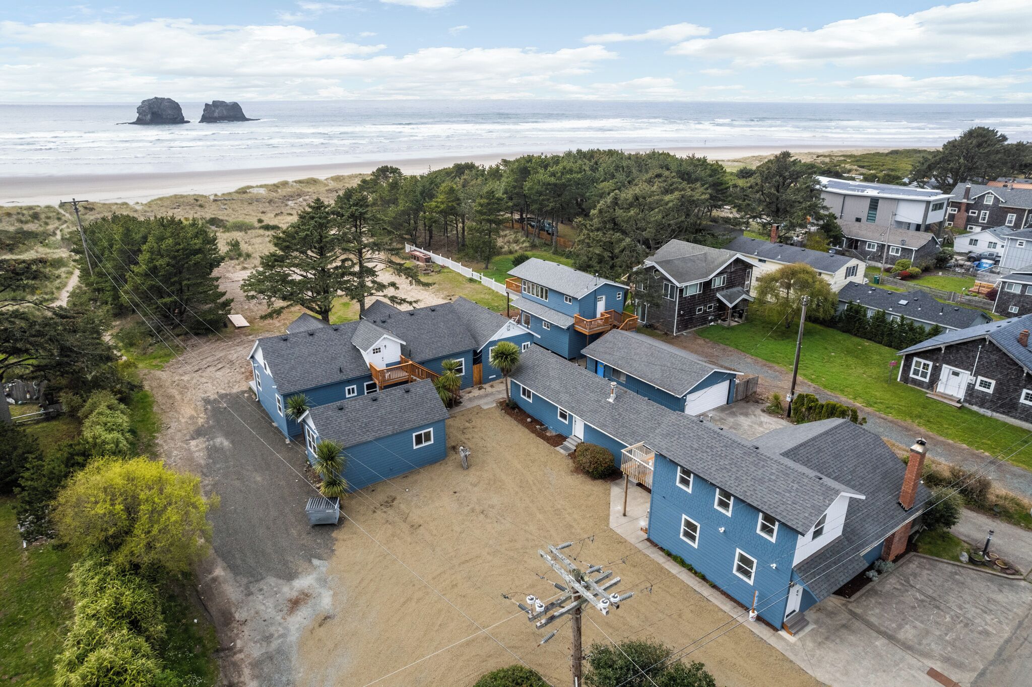 Zona residencial a la costa amb cases, una platja sorrenca i vista a l'oceà.