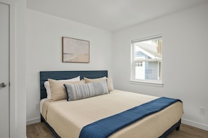 Une chambre à coucher avec un lit, une fenêtre et un tableau accroché au mur.