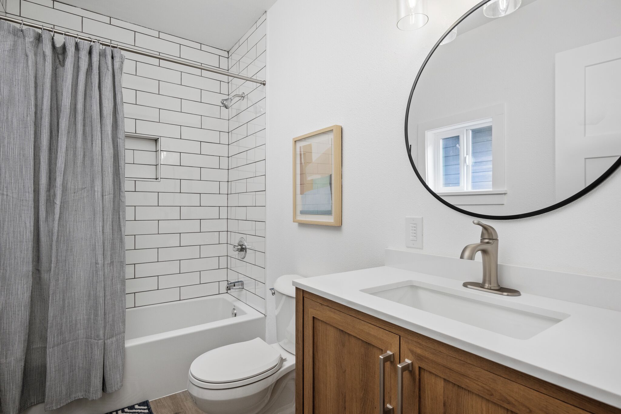 Une salle de bain avec une baignoire blanche, des toilettes, un lavabo et un rideau de douche.