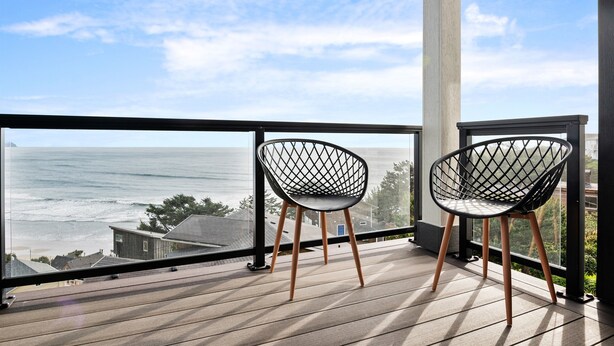Un balcon avec deux chaises donnant sur l’océan.