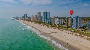 A coastal cityscape with a beach, high-rise buildings, and a pier extending into the ocean. - One bedroom ocean view Meridian plaza (Myrtle Beach)