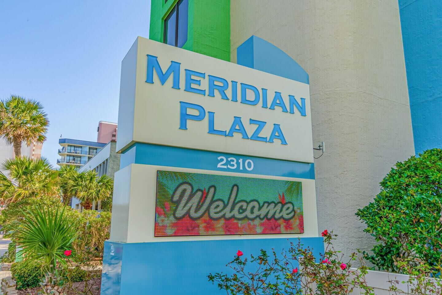 A sign for Meridian Plaza with a 'Welcome' message.