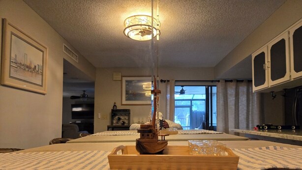 Une chambre d’hôtel avec un lit, une maquette de bateau en bois et un plateau avec des verres.