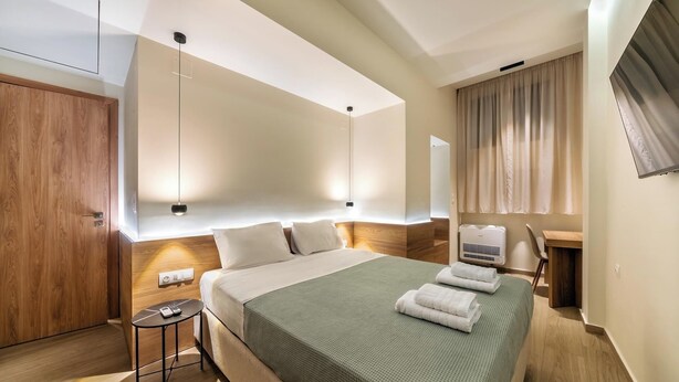 A modern hotel room with a large bed, a desk, and a wardrobe. - Your urban oasis in the heart of Chania Town,a blend of convenience and comfort. (Chania)