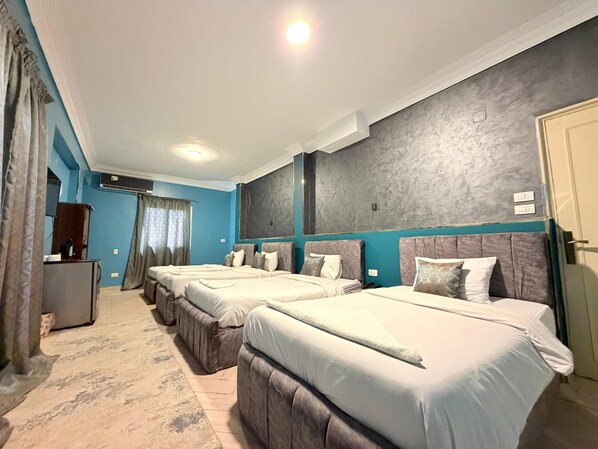 Neljän hengen deluxe-huone, kaupunkinäköala | Tallelokero huoneessa, työpöytä, äänieristys, silitysrauta/-lauta