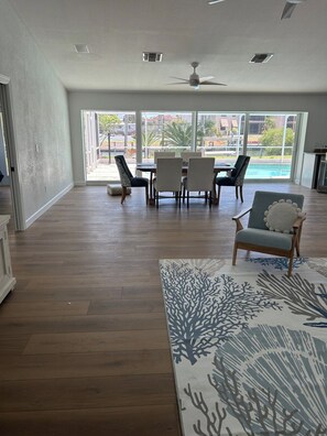 A spacious room with a dining area, a ceiling fan, and a view of a swimming pool. - Beautiful sanibel home (Sanibel)