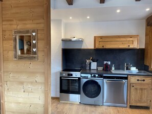 Una cocina moderna con electrodomésticos de acero inoxidable, armarios de madera y horno empotrado.