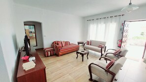 A living room with a sofa set, a coffee table, and a TV.