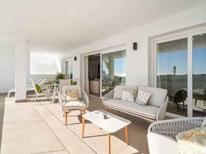 A modern outdoor living space with a sofa, chairs, and a table. - Stylish 2-bedroom Apartment in Casares (Casares)