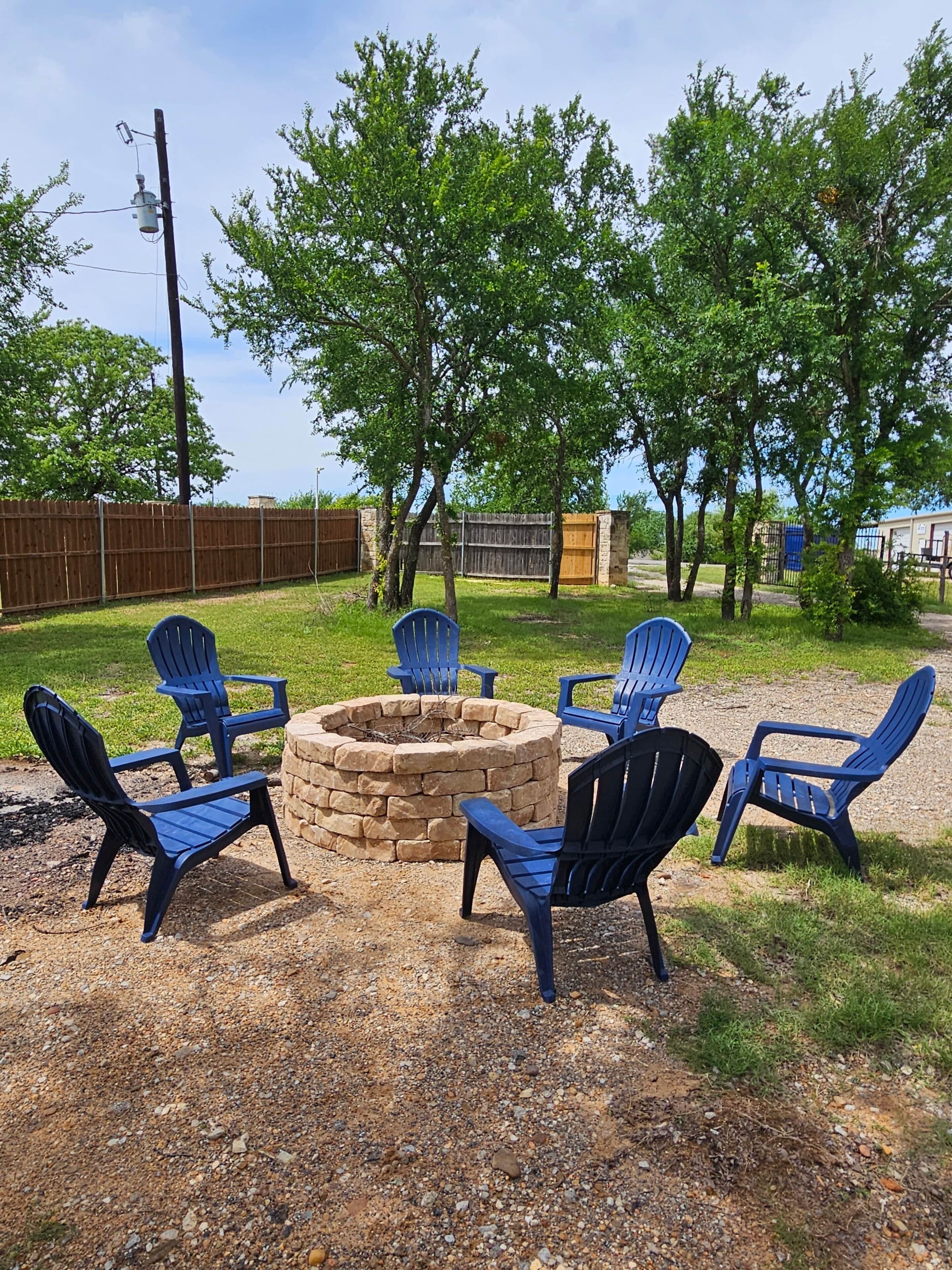 Un foyer extérieur entouré de chaises, installé dans un jardin.