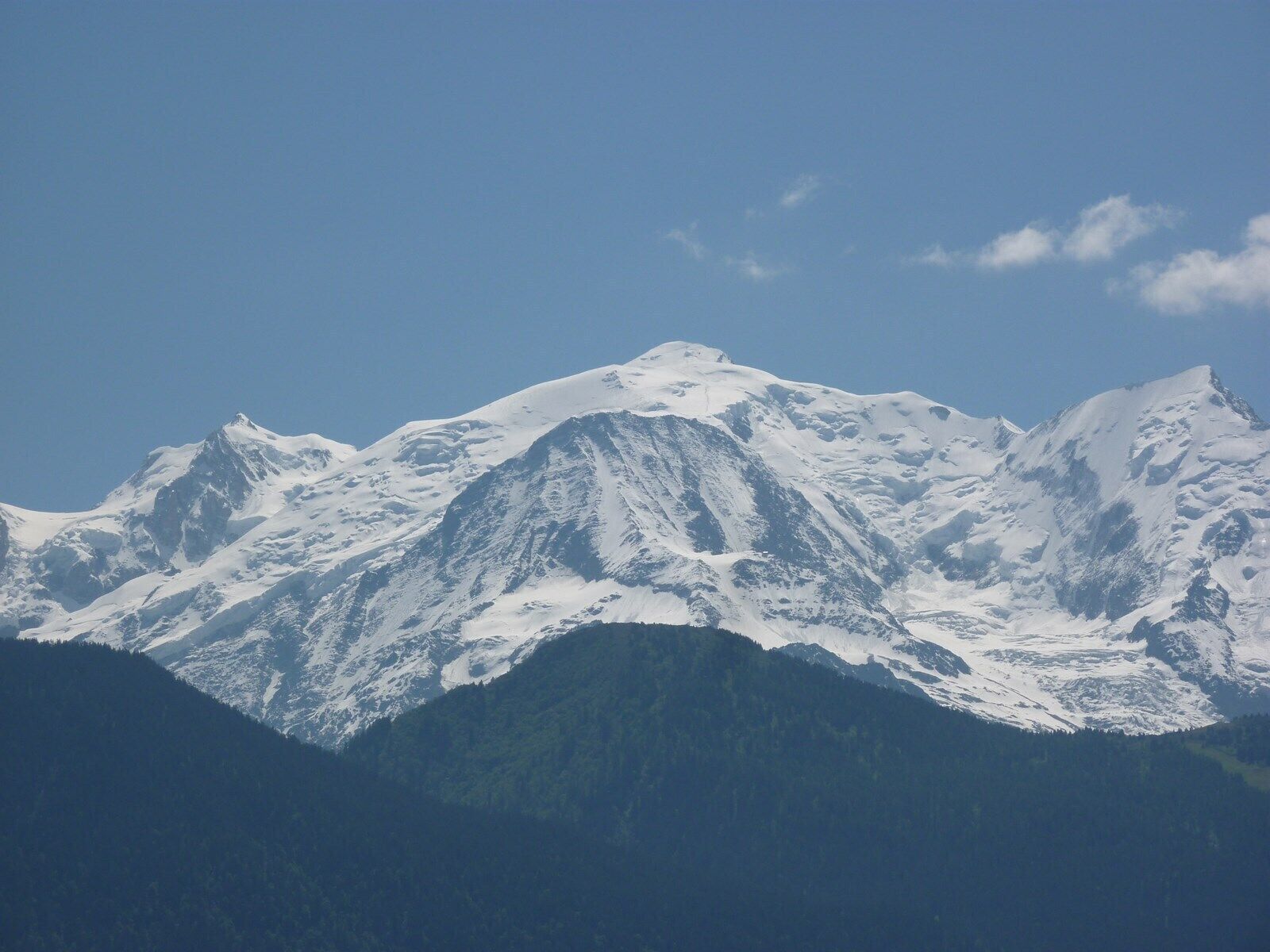Une chaîne de montagnes enneigée sous un ciel dégagé.