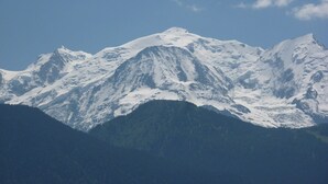 Ein schneebedecktes Gebirge unter blauem Himmel.