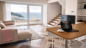 Ein modernes Wohnzimmer mit einer Couch, einem Couchtisch und einem Laptop auf einem Holztisch.