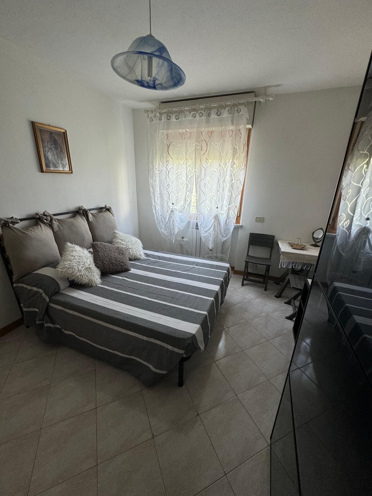 A bedroom with a bed, a desk, and a chair.