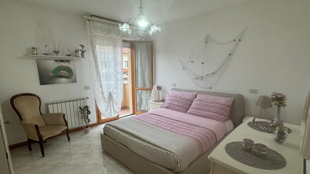 A bedroom with a bed, a chair, a desk, and a window with curtains. - The house of mihaela 10 minutes from the private beach le Dune di Forte dei marmi (Capanne-Prato-Cinquale)
