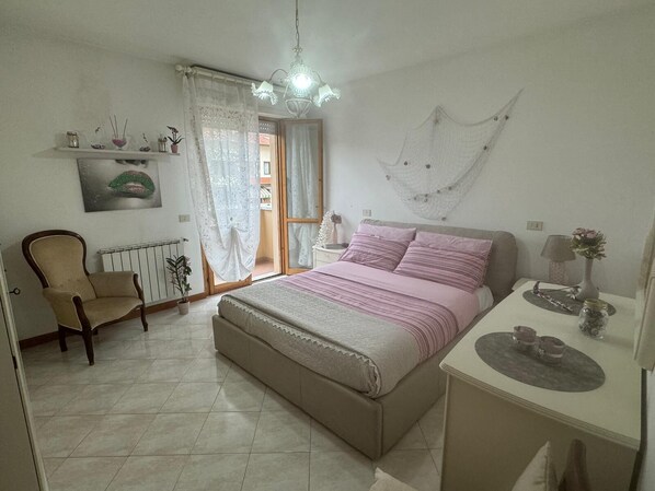 A bedroom with a bed, a chair, a desk, and a window with curtains. - The house of mihaela 10 minutes from the private beach le Dune di Forte dei marmi (Capanne-Prato-Cinquale)