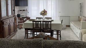 A living room with a dining table, a TV, and a cabinet. - The house of mihaela 10 minutes from the private beach le Dune di Forte dei marmi (Capanne-Prato-Cinquale)