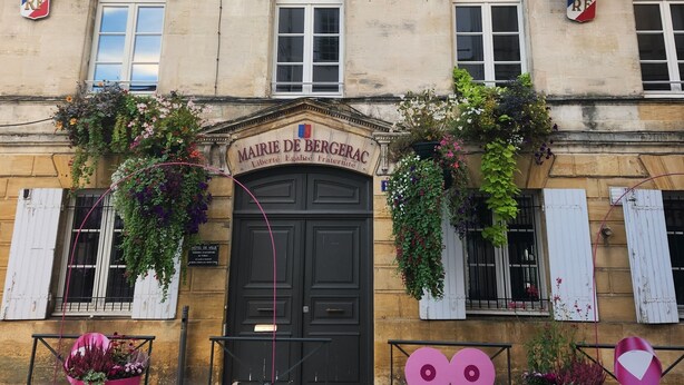 A historic building with a black entrance door, multiple windows, and flags. - Cosy House With Swimming Pool - Bergerac (5 minutes from downtown) (Bergerac)