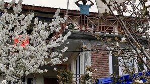 Et boligområde med et hus, der har en murstensfacade og en metalbalkon.
