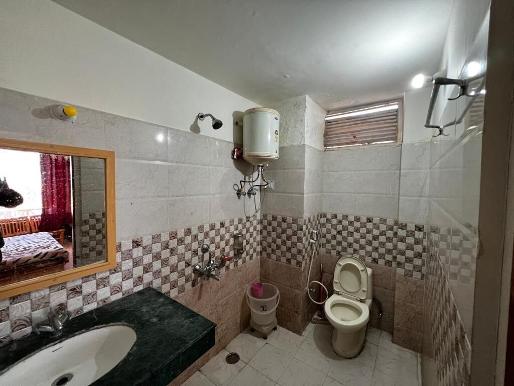 A bathroom with a sink, toilet, and a mirror.