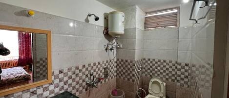 A bathroom with a sink, toilet, and a mirror.