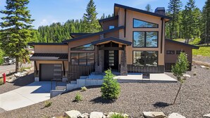 A modern two-story house with a garage, a covered porch, and a driveway. - Brundage Luxury Retreat | Hike • Bike • Relax (McCall)