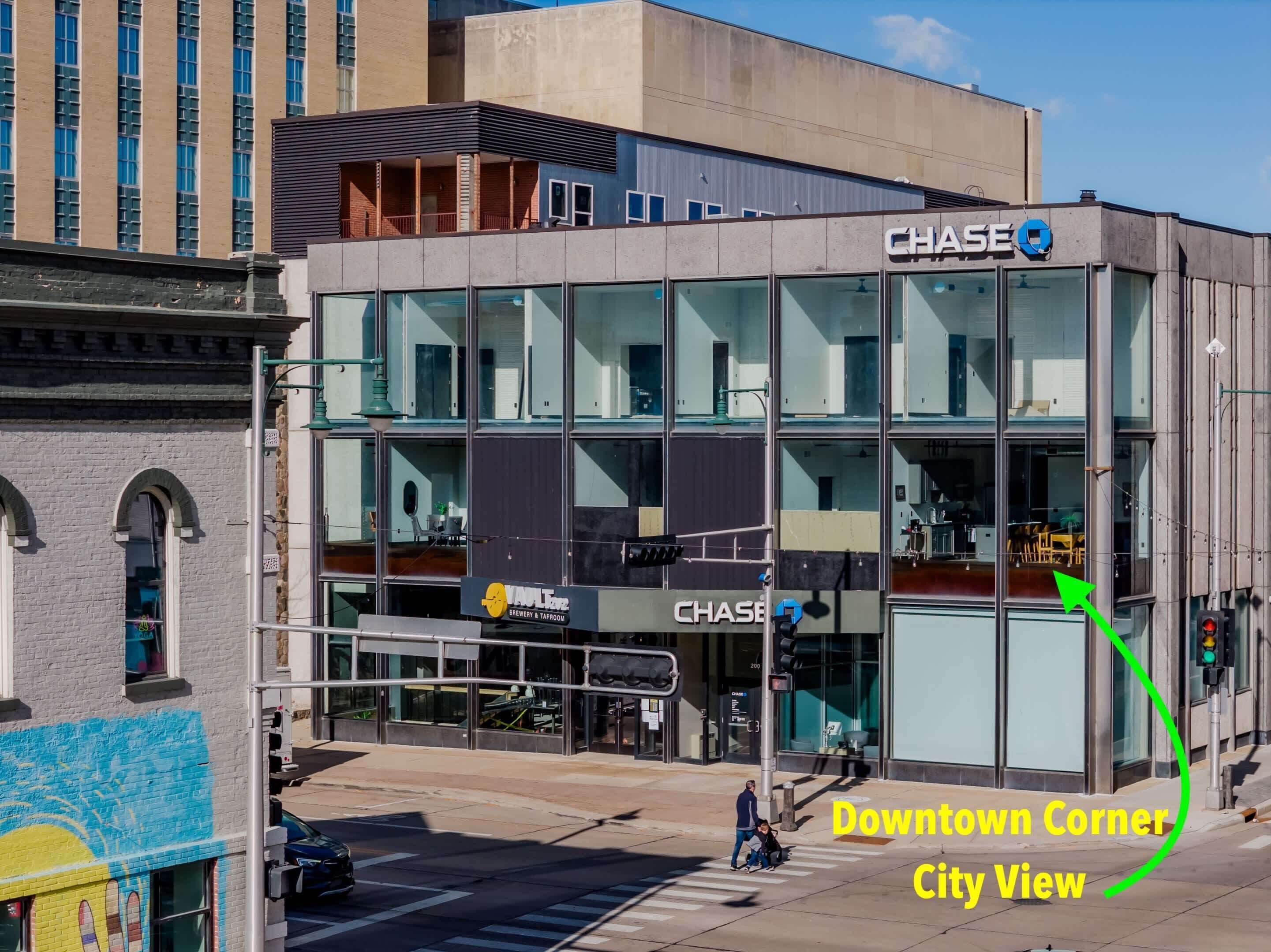 Ein modernes Gebäude mit Glasfassade, einer Chase Bank im Erdgeschoss und einem Schild für eine Brauerei und ein Taproom.