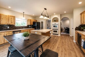 Una cocina moderna con armarios de madera, una isla central y un comedor.