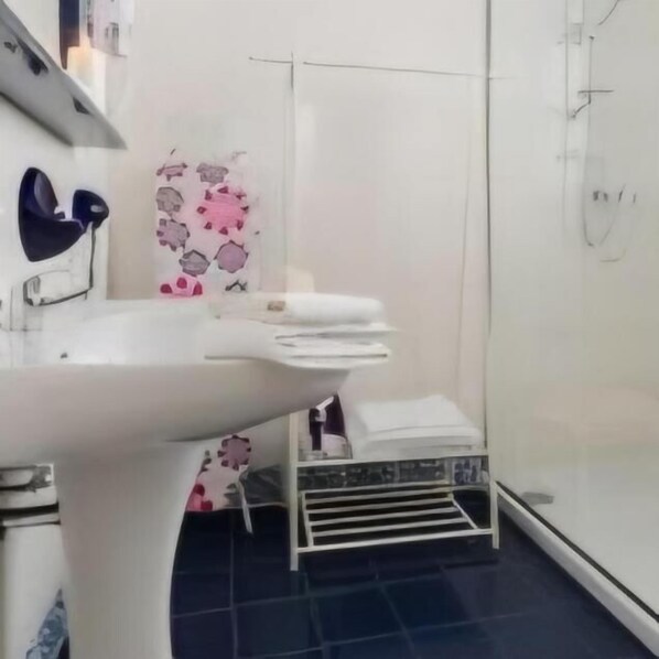 A bathroom with a white sink, a towel rack, and a shower area. - Equinox house (Tuglie)